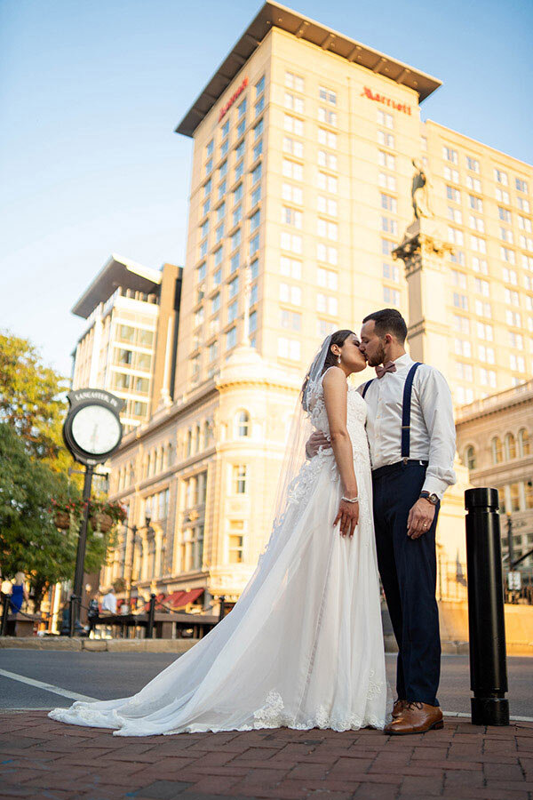 Bride &amp; Groom Kissing in front of the Lancaster Marriott at Penn Square