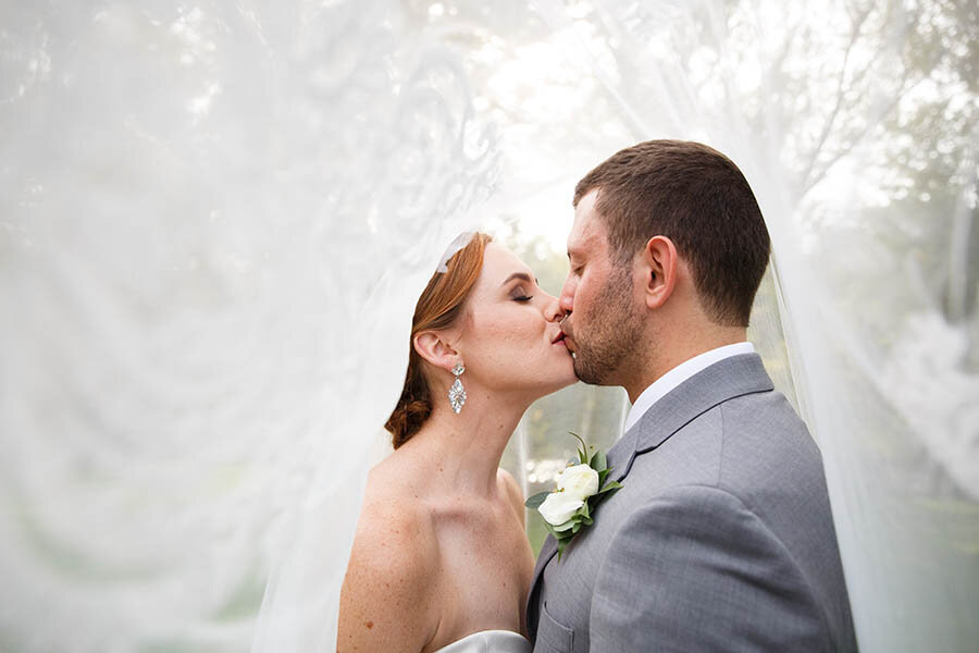 Bride &amp; Groom Veil Shot Kissing