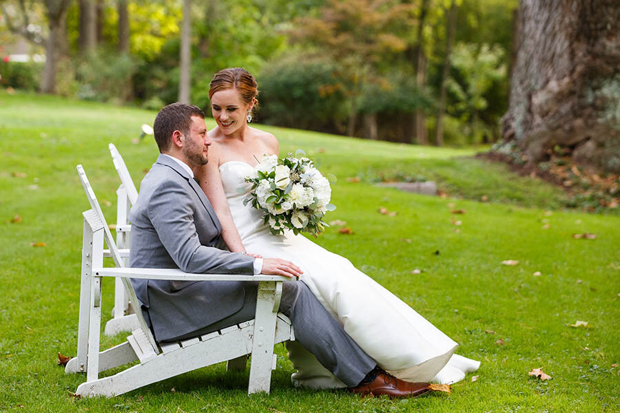 Bride &amp; Groom Seated in Adirondack Chairs at Riverdale Manor