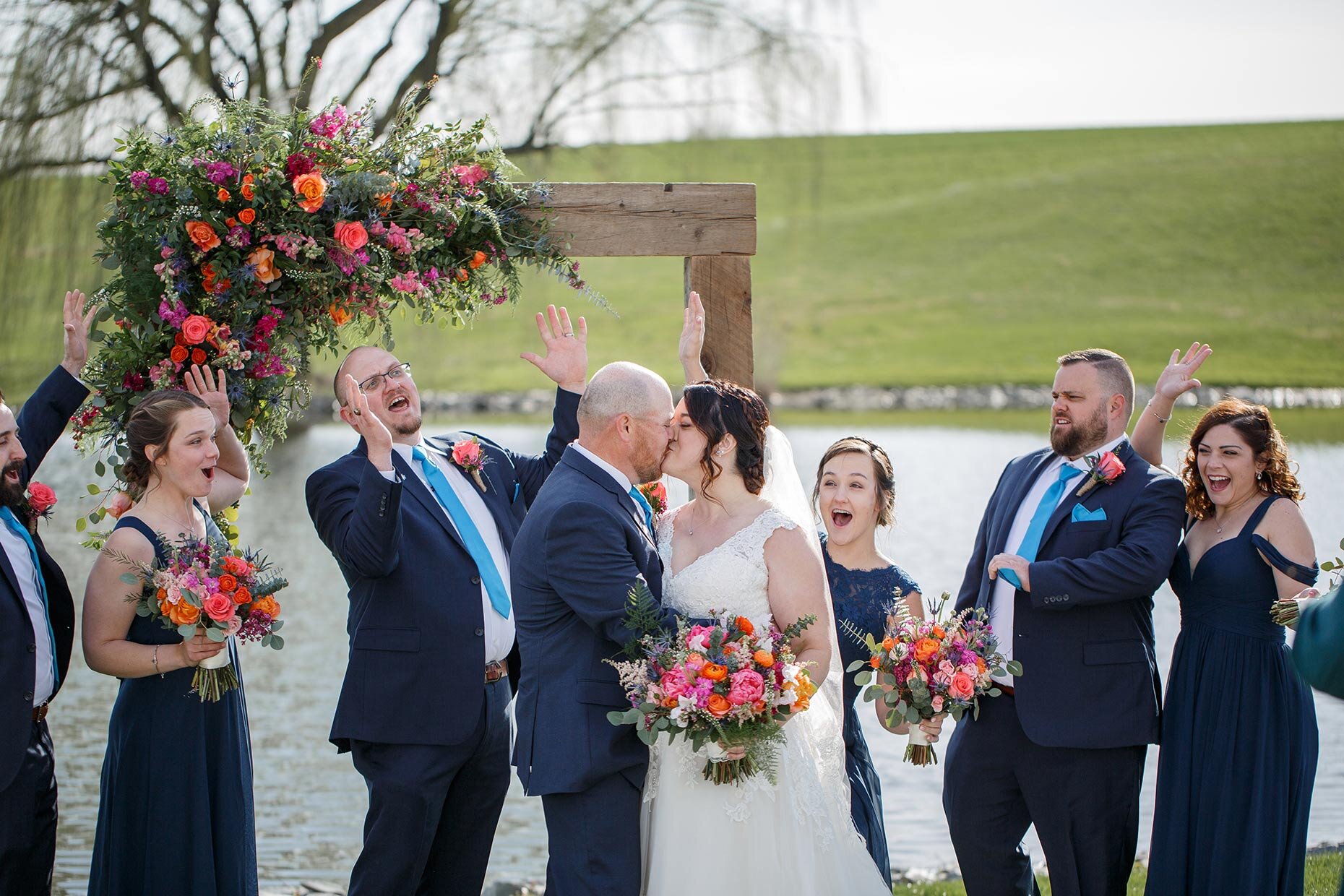 Bridal Party Cheers for Bride and Groom’s Kiss