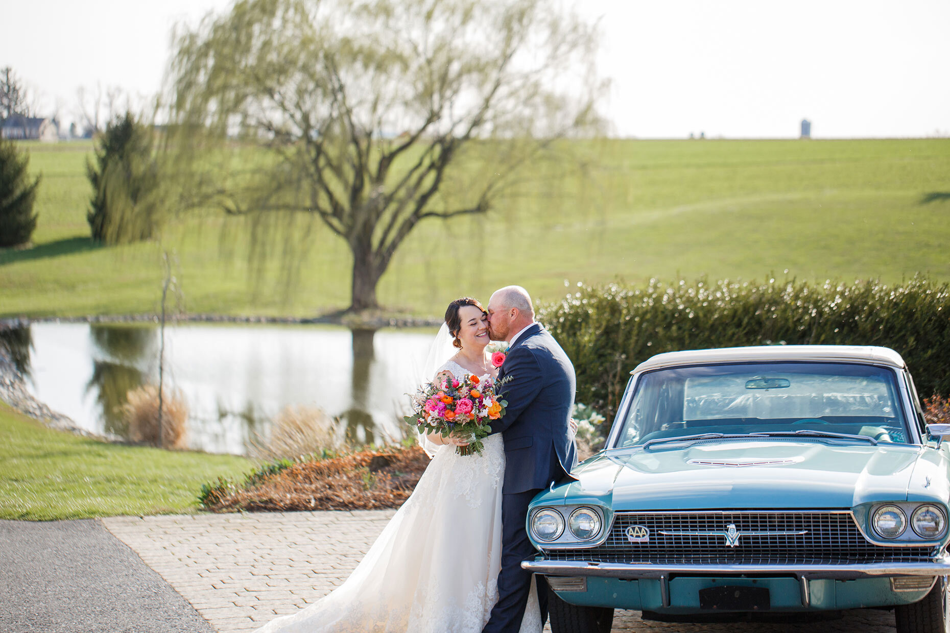 Groom Kisses Bride with Classic Car