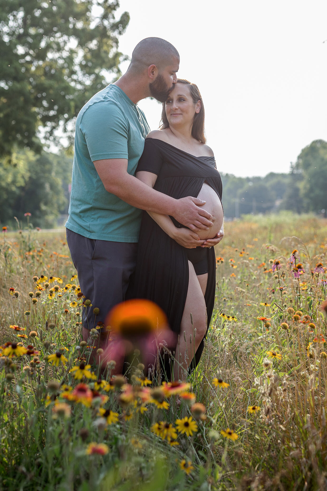 Maternity shoot with couple in Flower field at Golden Hour in black dress