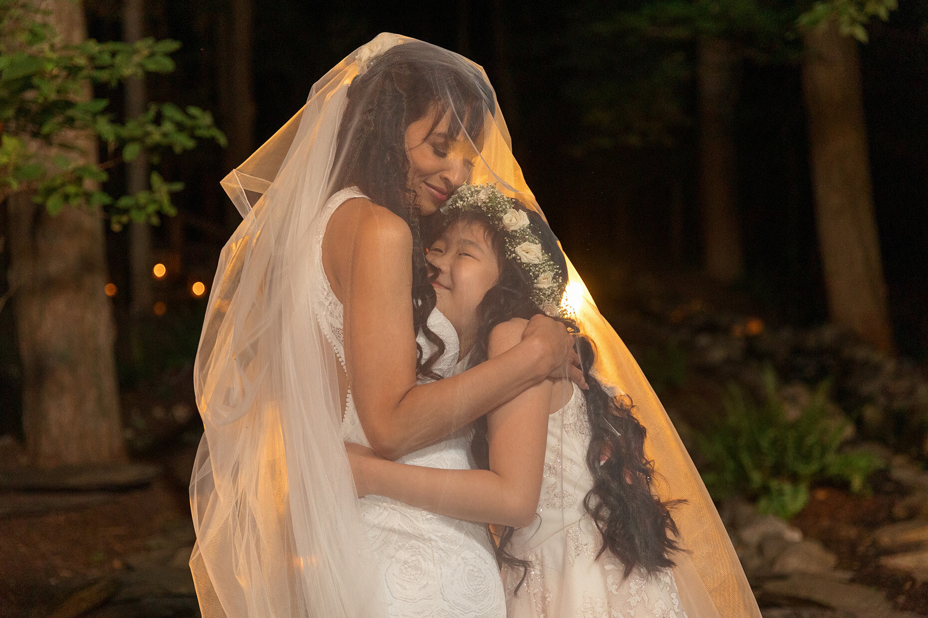 Mother daughter hugging under veil