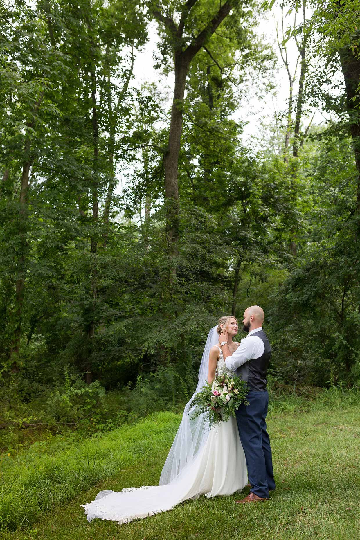 Bride and groom in a forest looking at each other