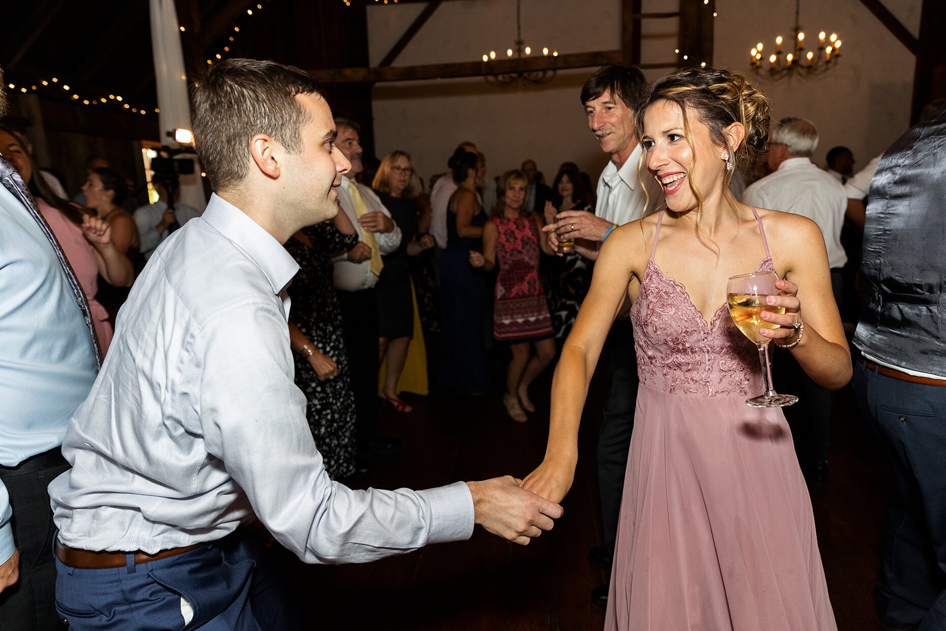Bridesmaid dances with wine at reception