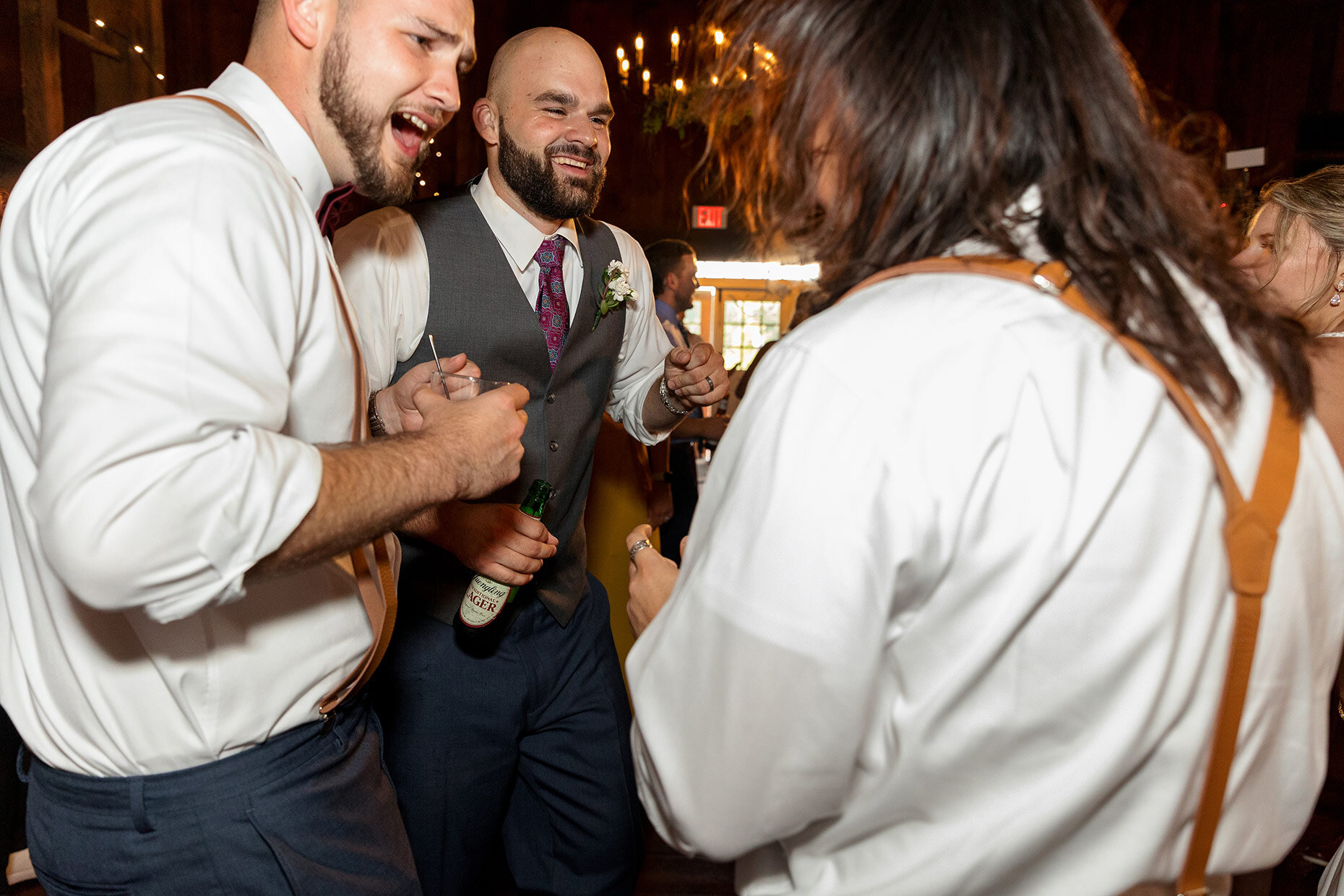 Groom dances with friends at reception
