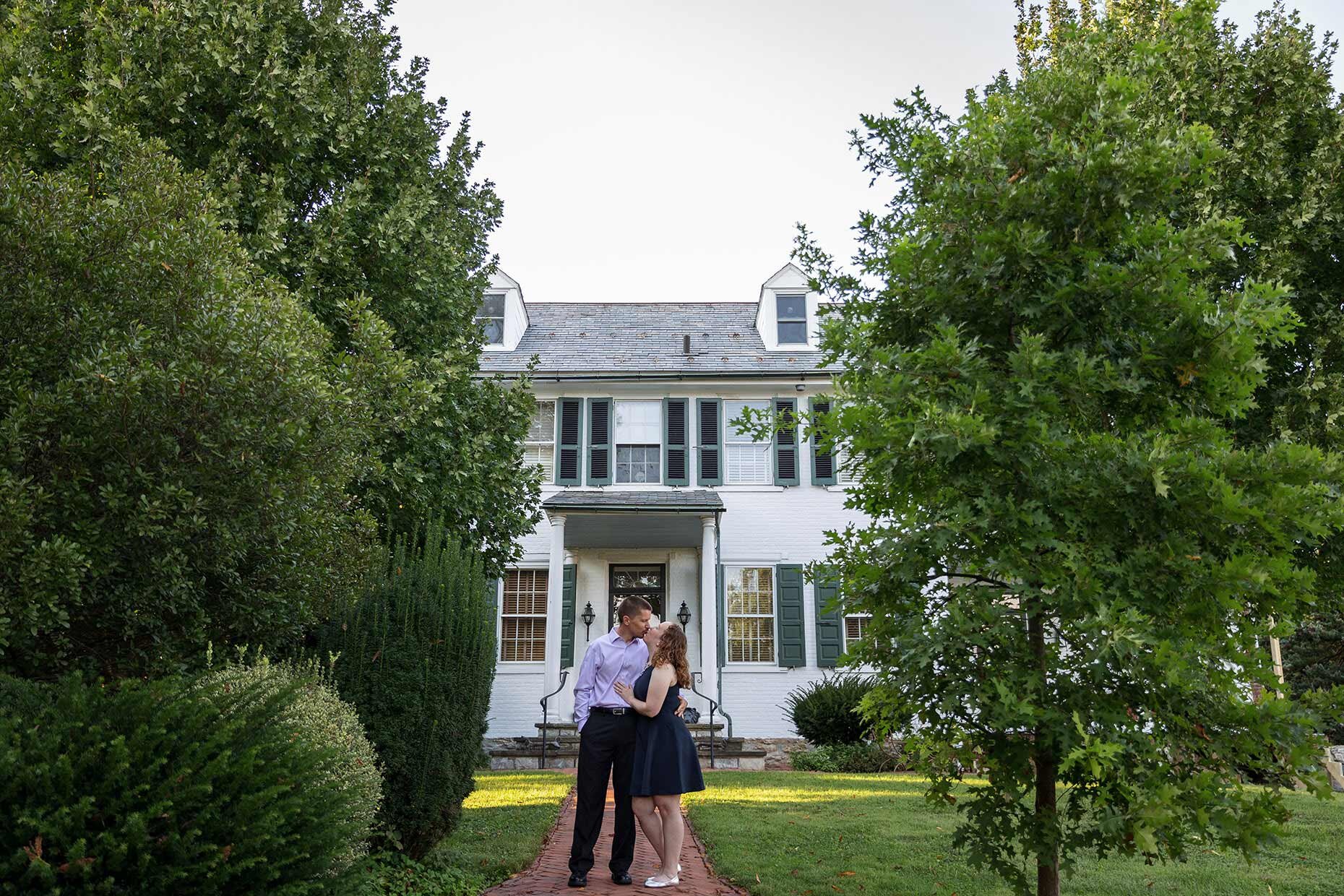 Couple kissing in front of a White House 