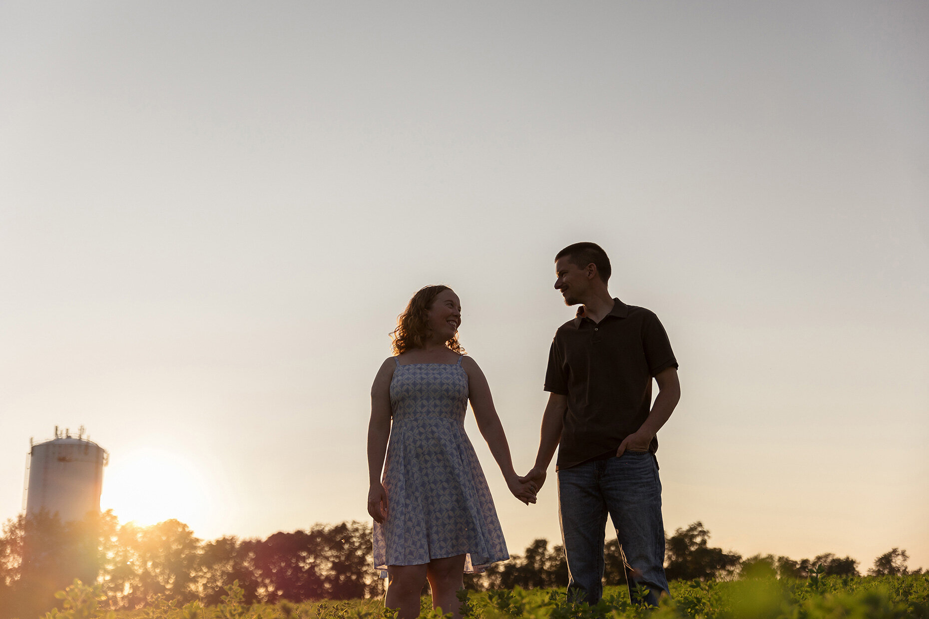 Holding hands standing in a field engagement photos 