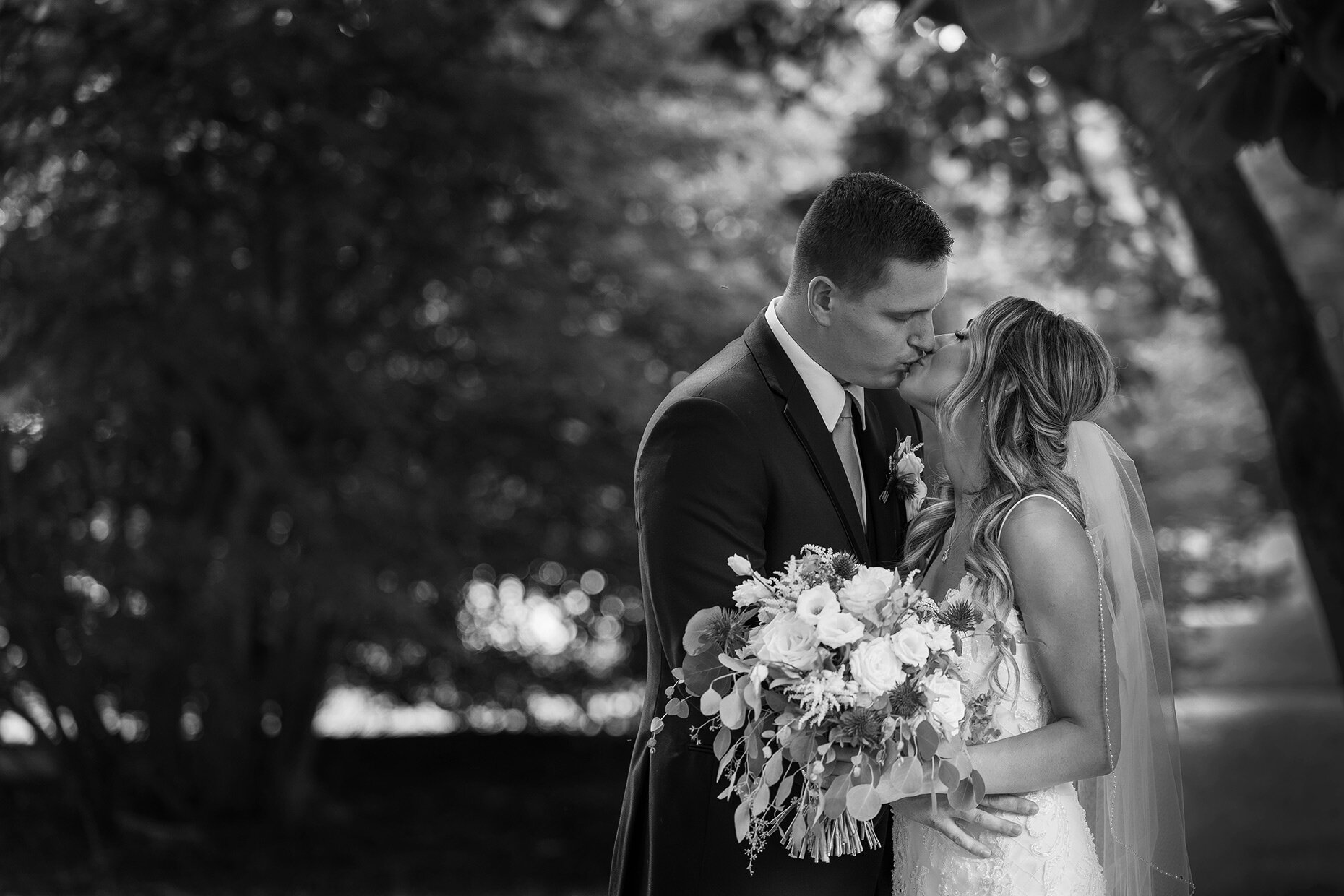 Dramatic black and white bride and groom kissing