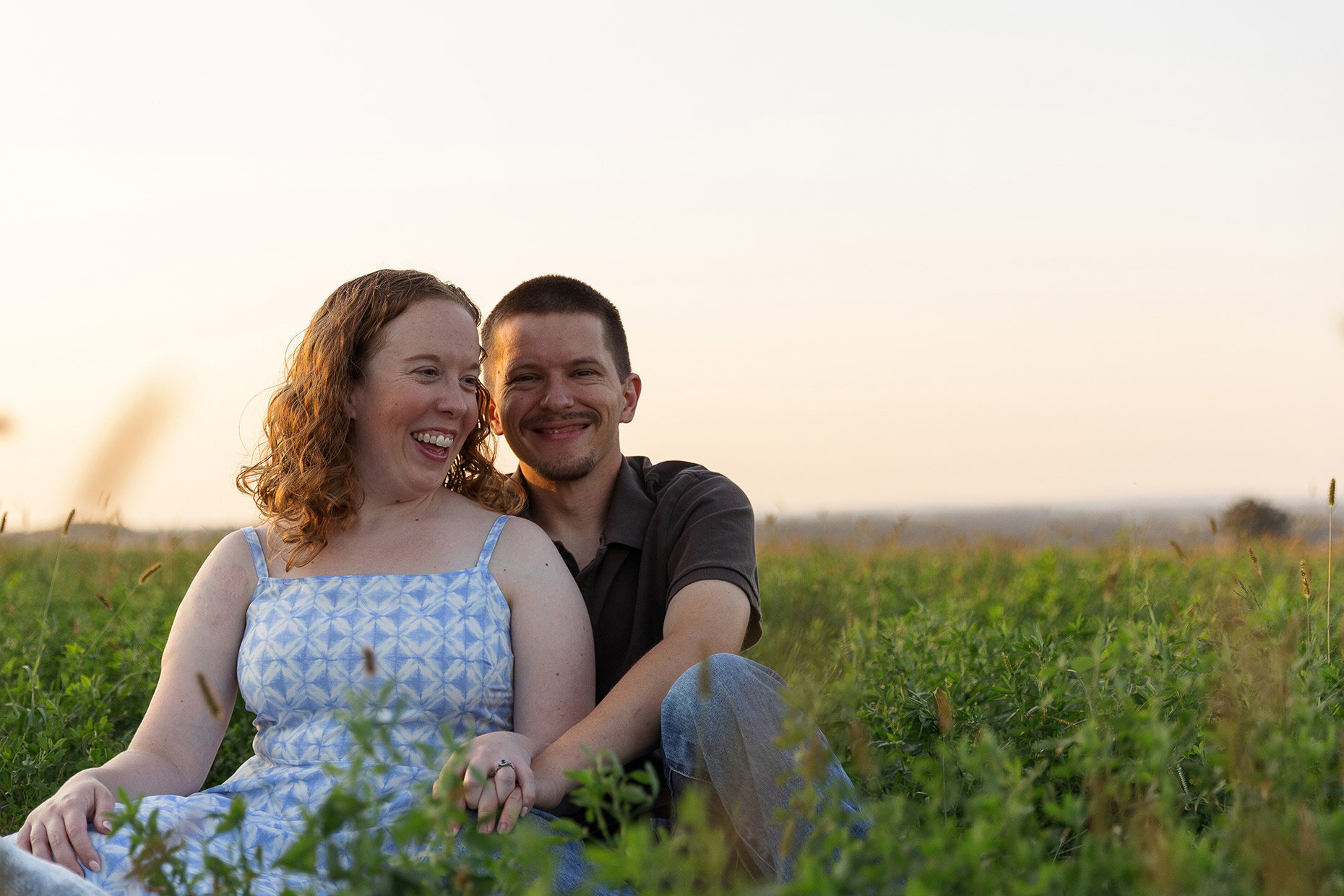 Engaged Couple Sitting in a field