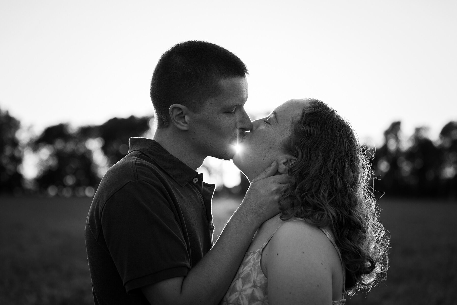 Couple kissing in field in black and white 