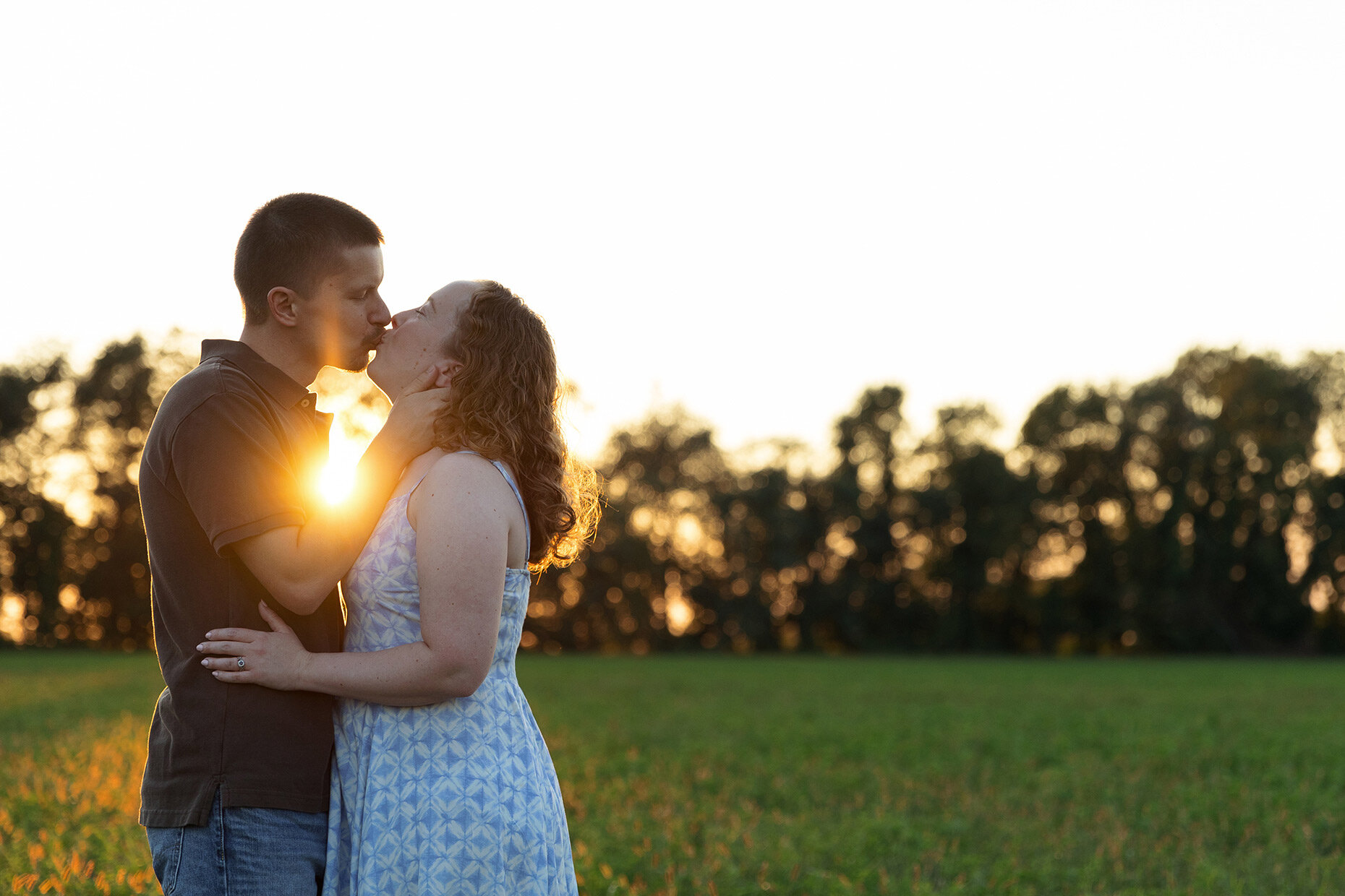 Couple kissing in sunset sunburst 