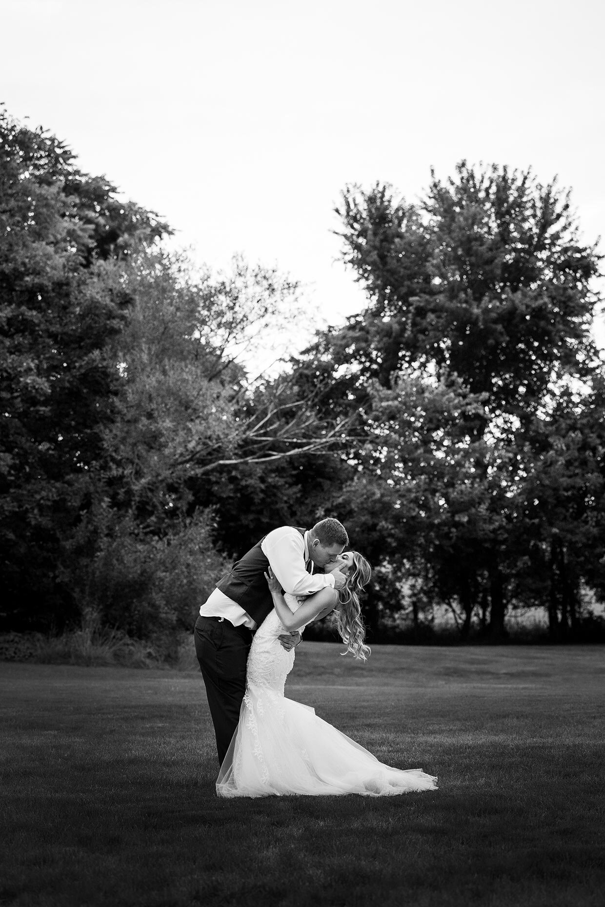 Groom dipping bride in black and white 