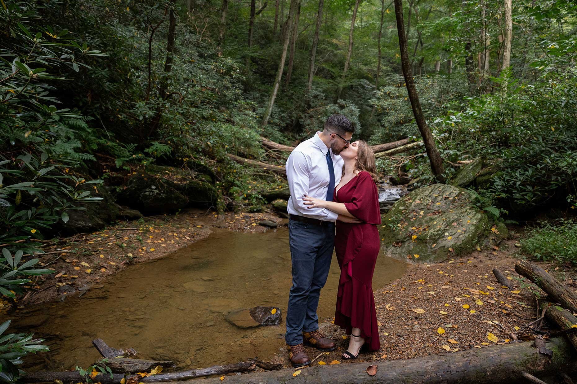 Engagement Photo Kissing at Creek in the woods