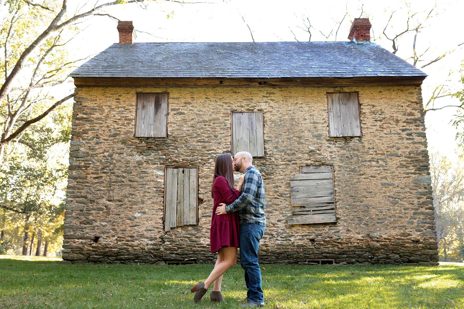 Engaged Couple Kissing in front of the James B. Long Home at Susquehannock State Park