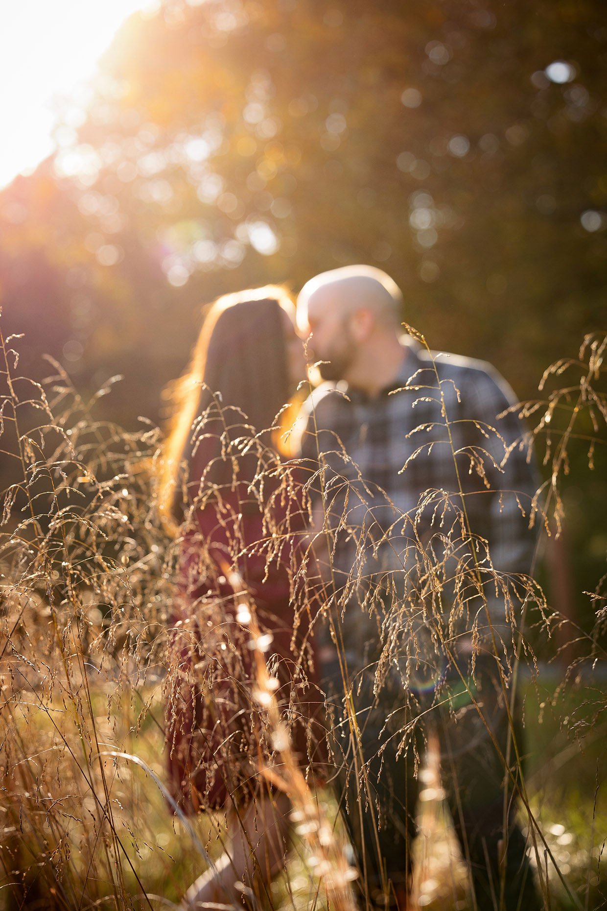 Out of focus photo of couple kissing in grassy field