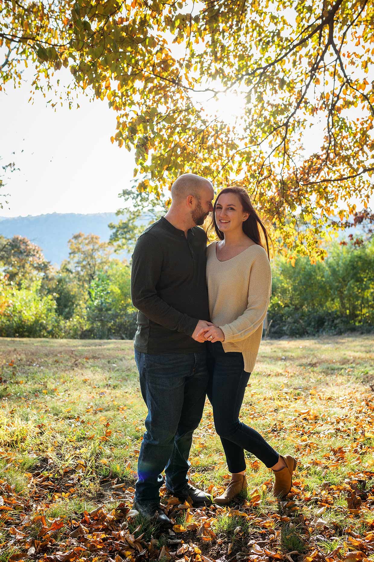 Backlit couple in front of trees in autumn