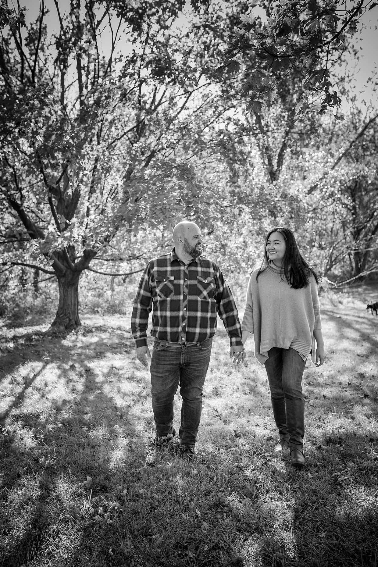 couple walking under a tree in black and white
