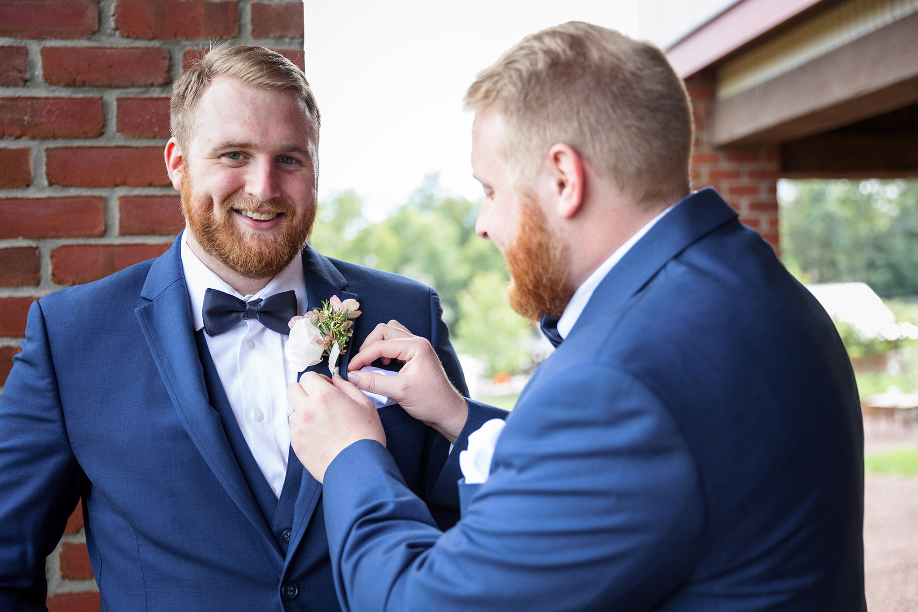 Brother Pinning Boutonniere on Groom Best Man