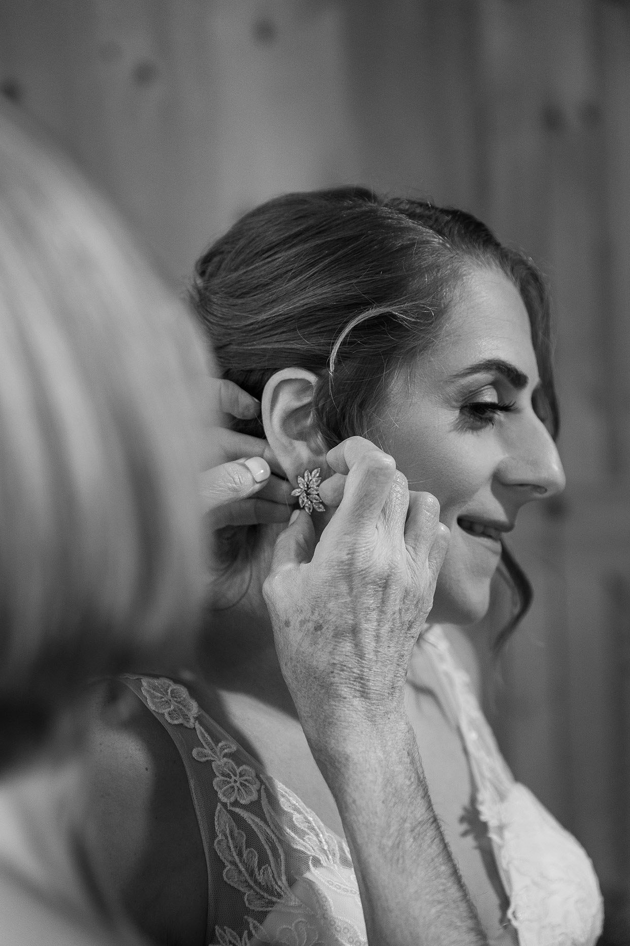 Mother of the bride fixing bride's earrings