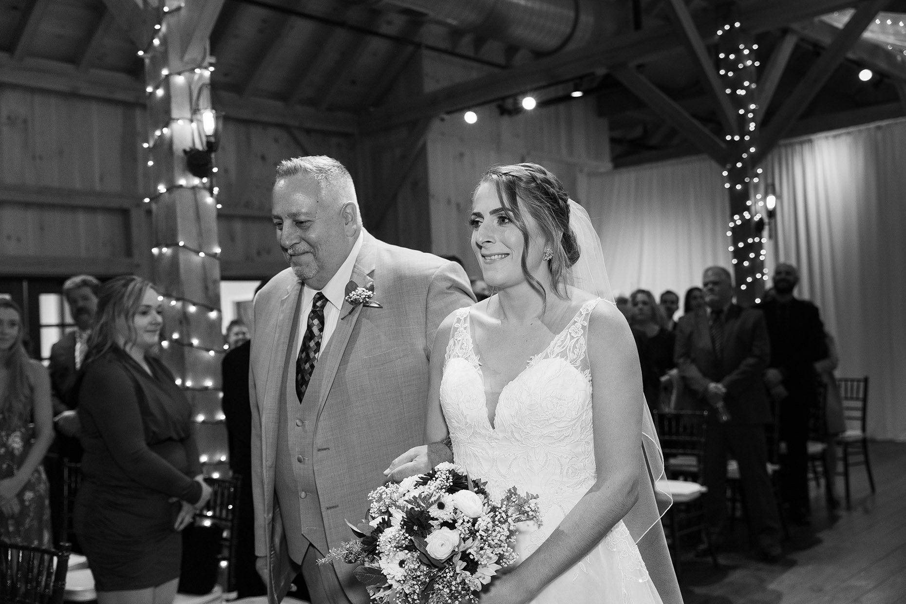 Black and white of bride's reaction walking down the aisle