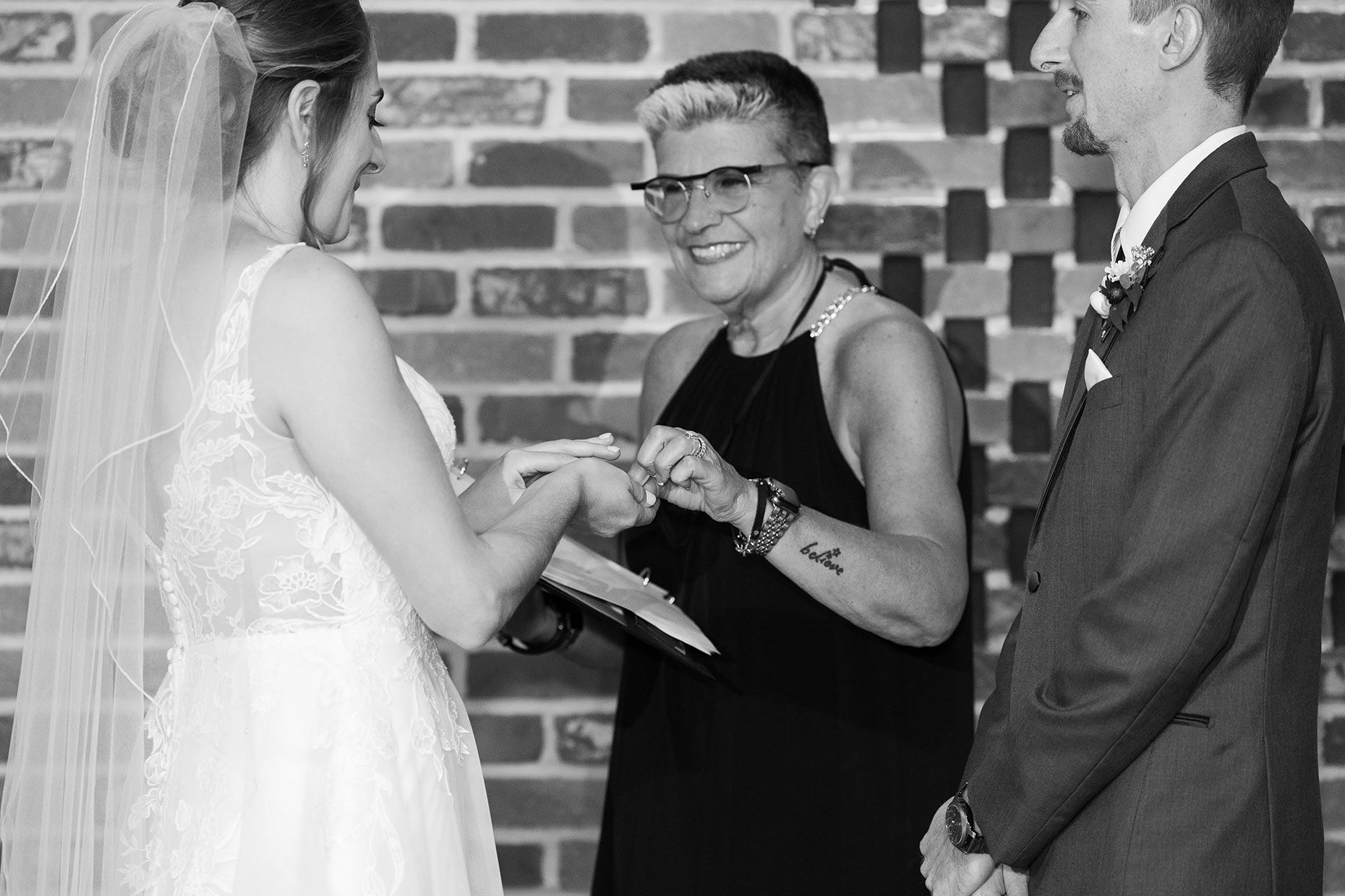 Officiant handing ring to bride