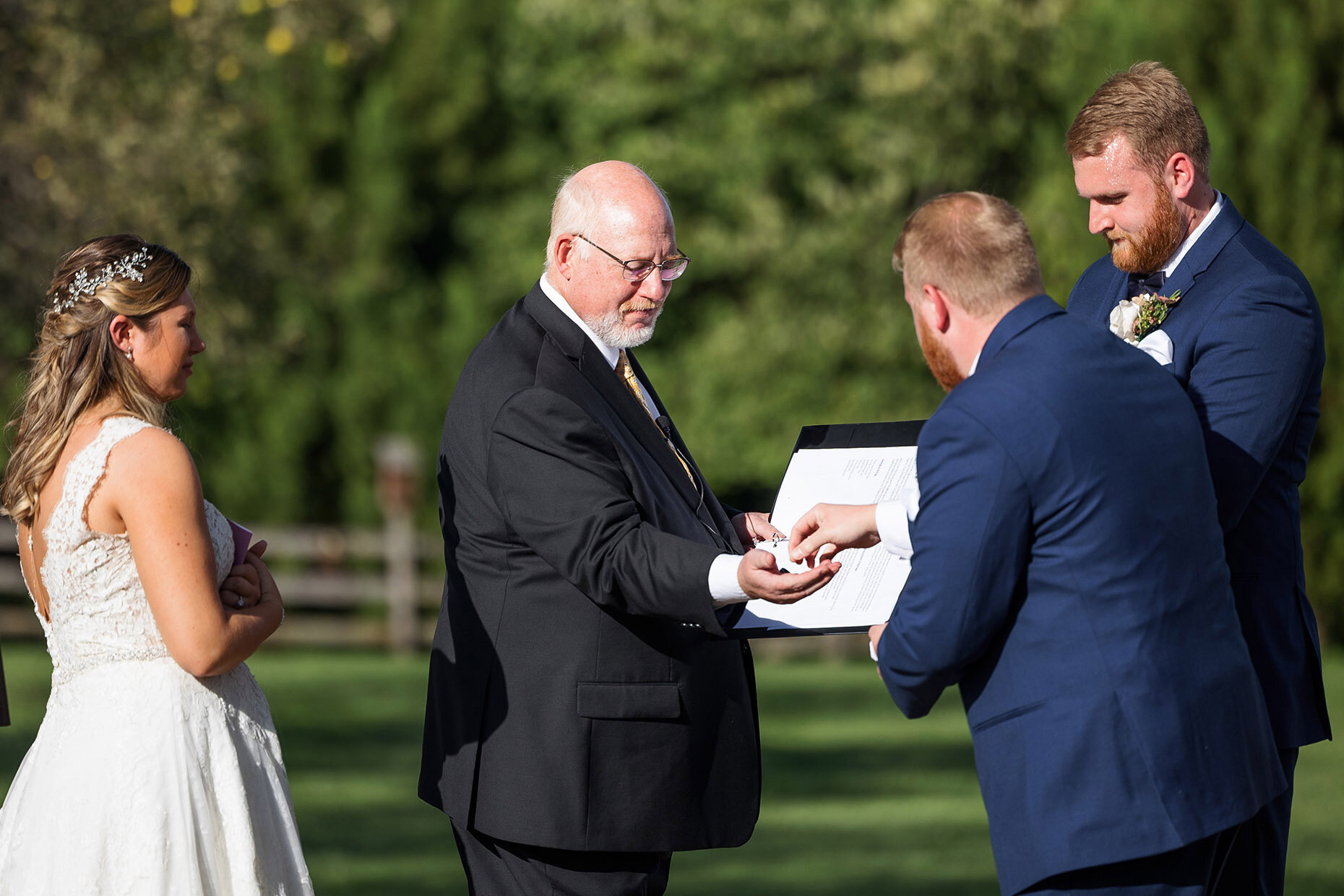 Best man hands rings to officiant 