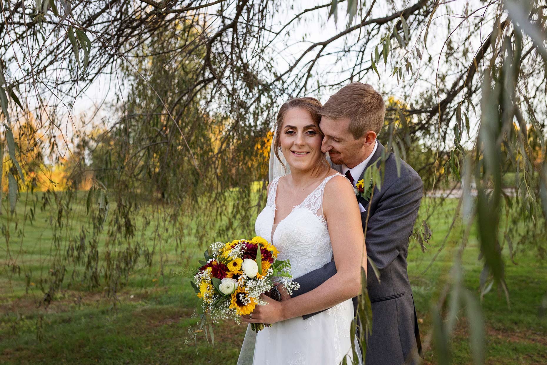 Groom Nuzzling Bride under a willow tree
