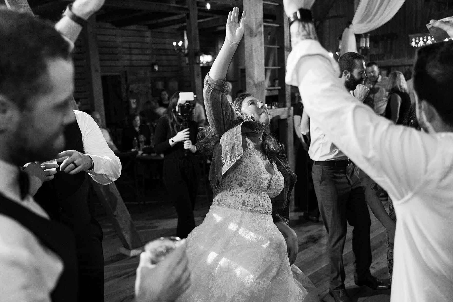 Bride dancing in denim jacket at reception 