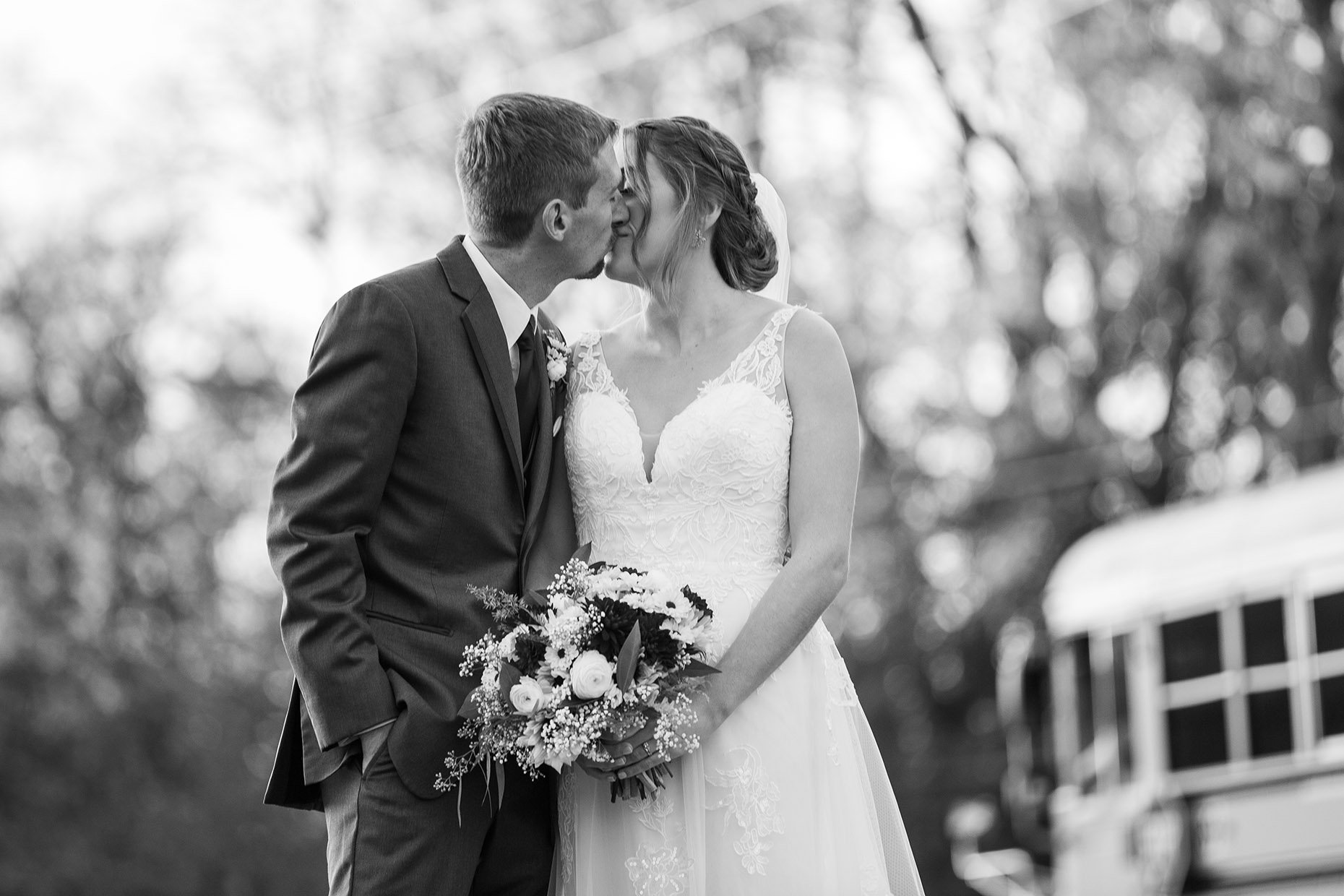 Bride &amp; groom kissing in black and white