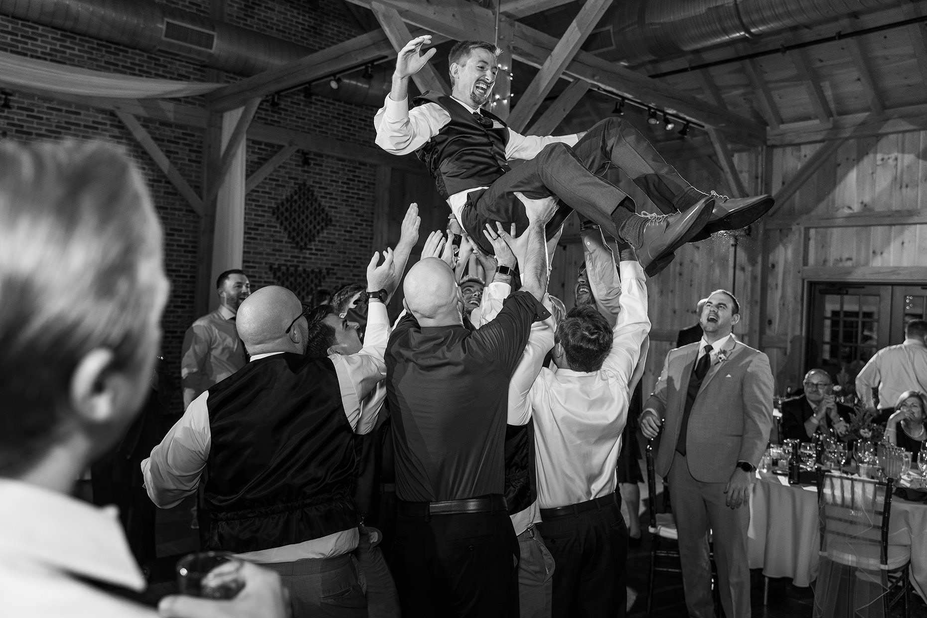 Groom being lifted at reception