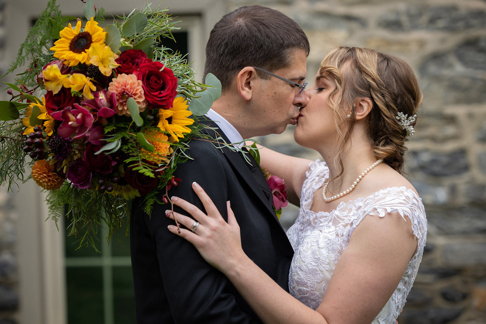 Bride and groom kissing with sunflowers