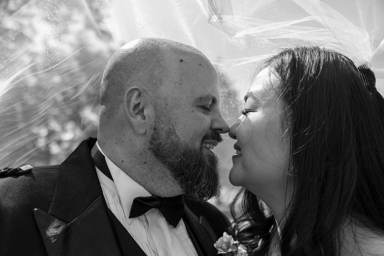 Bride & Groom under veil kissing with noses
